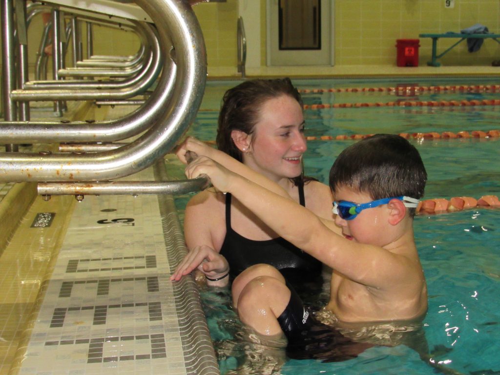 Swim Instructor helping youth swimmer